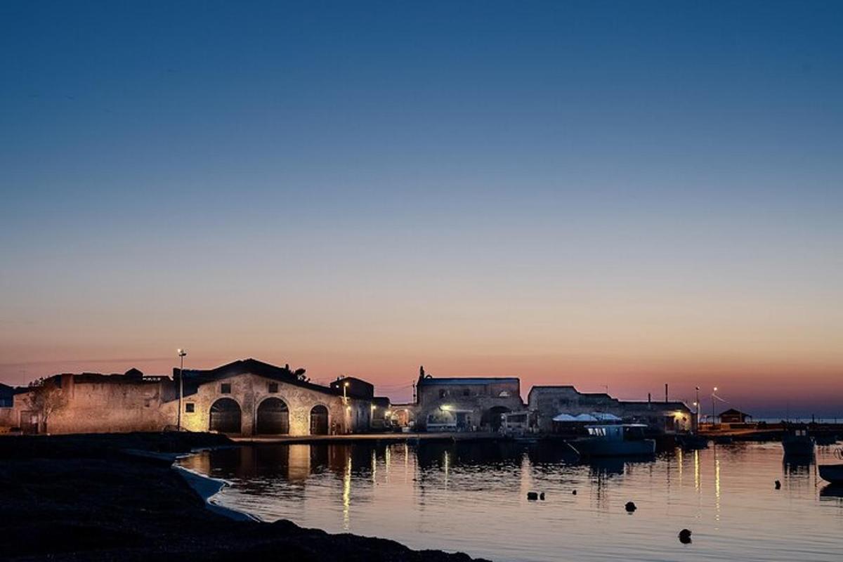 a group of buildings on the water at sunset