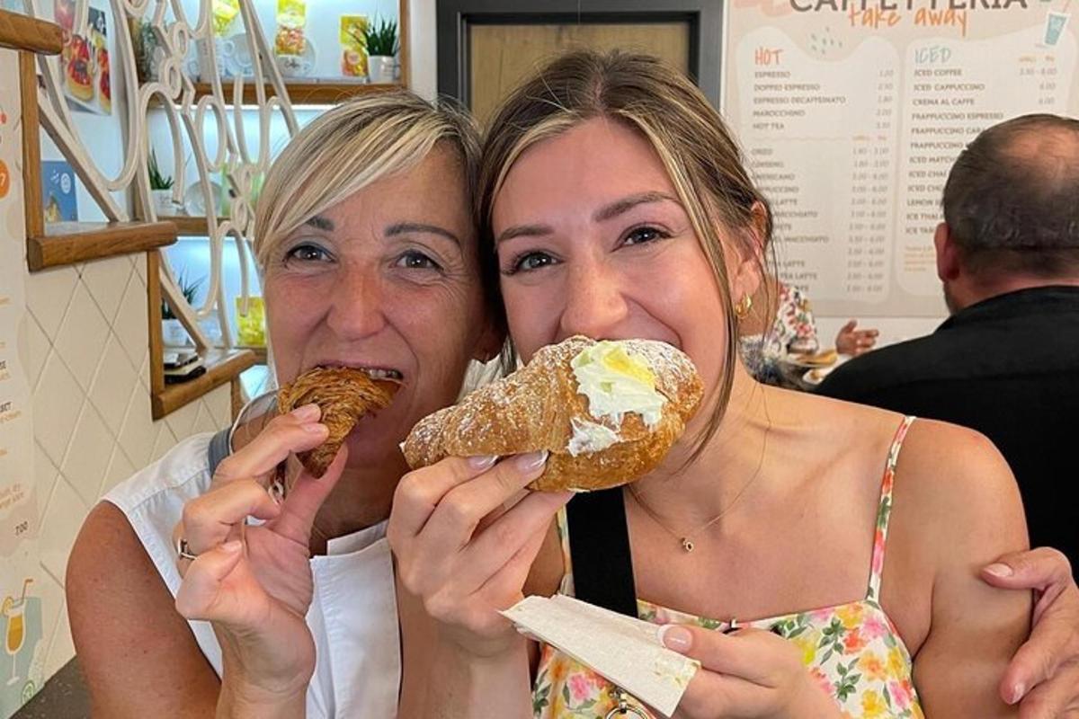 two women are eating donuts in a restaurant