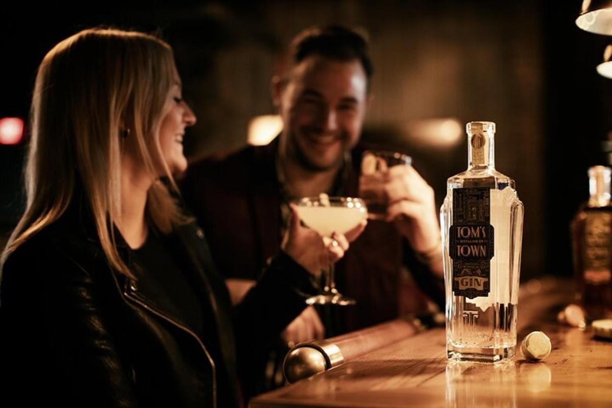 a man and woman sitting at a bar with a bottle of alcohol