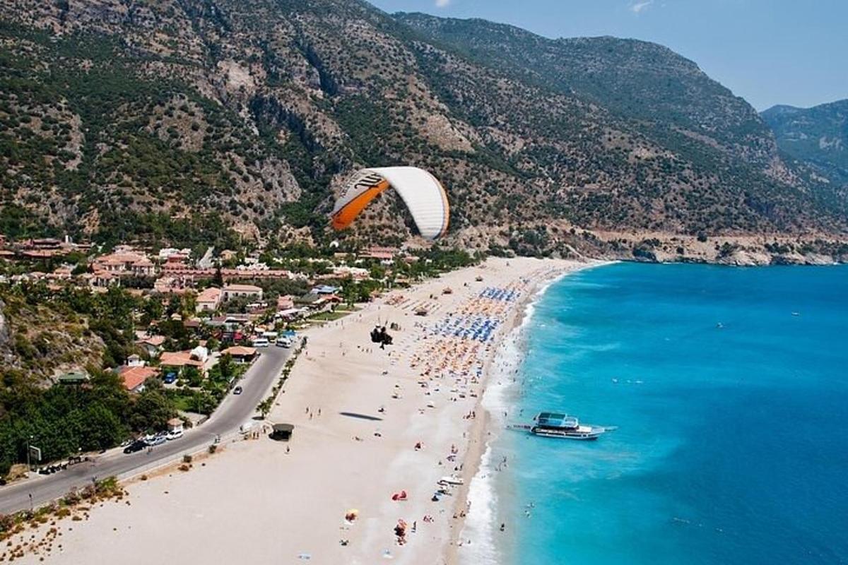 Jadralno padalo leti nad plažo z ljudmi