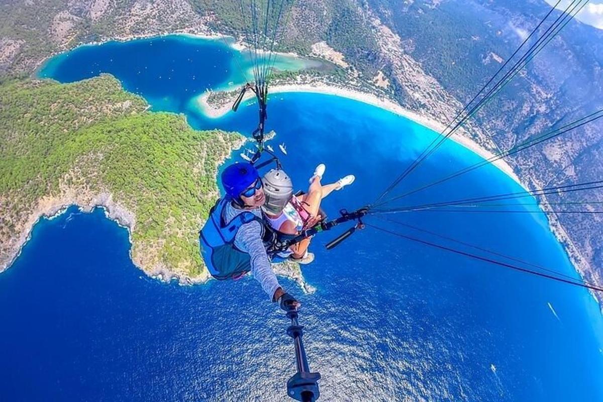 Dva človeka se s padalom dvigata nad oceanom