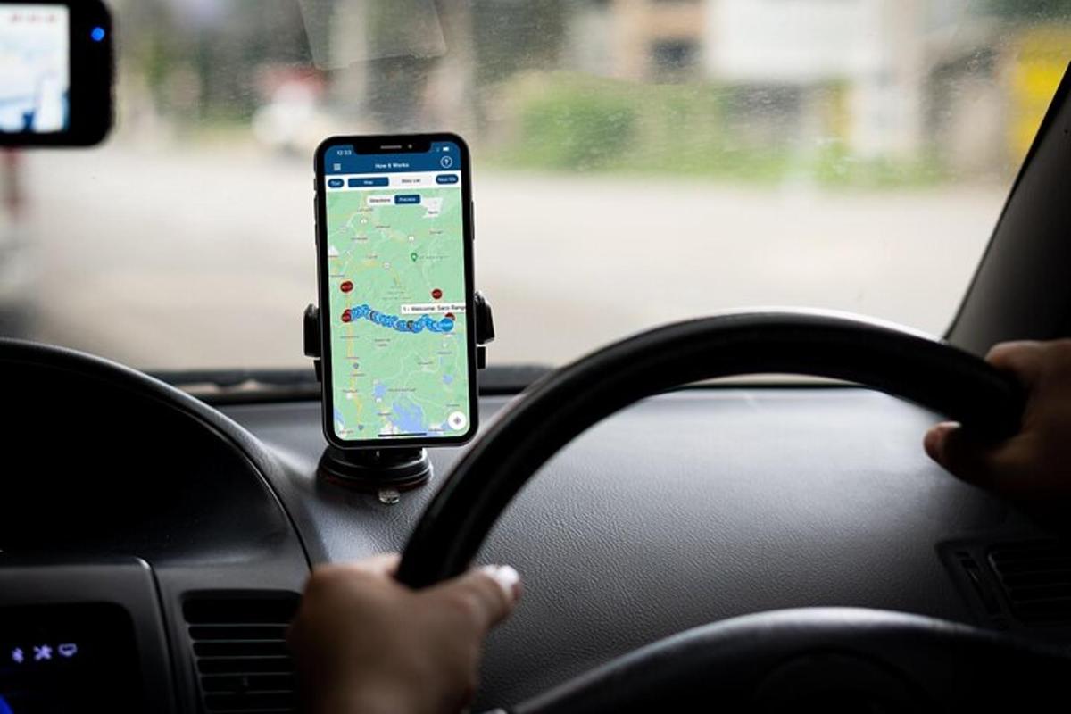 a person driving a car while holding a cell phone