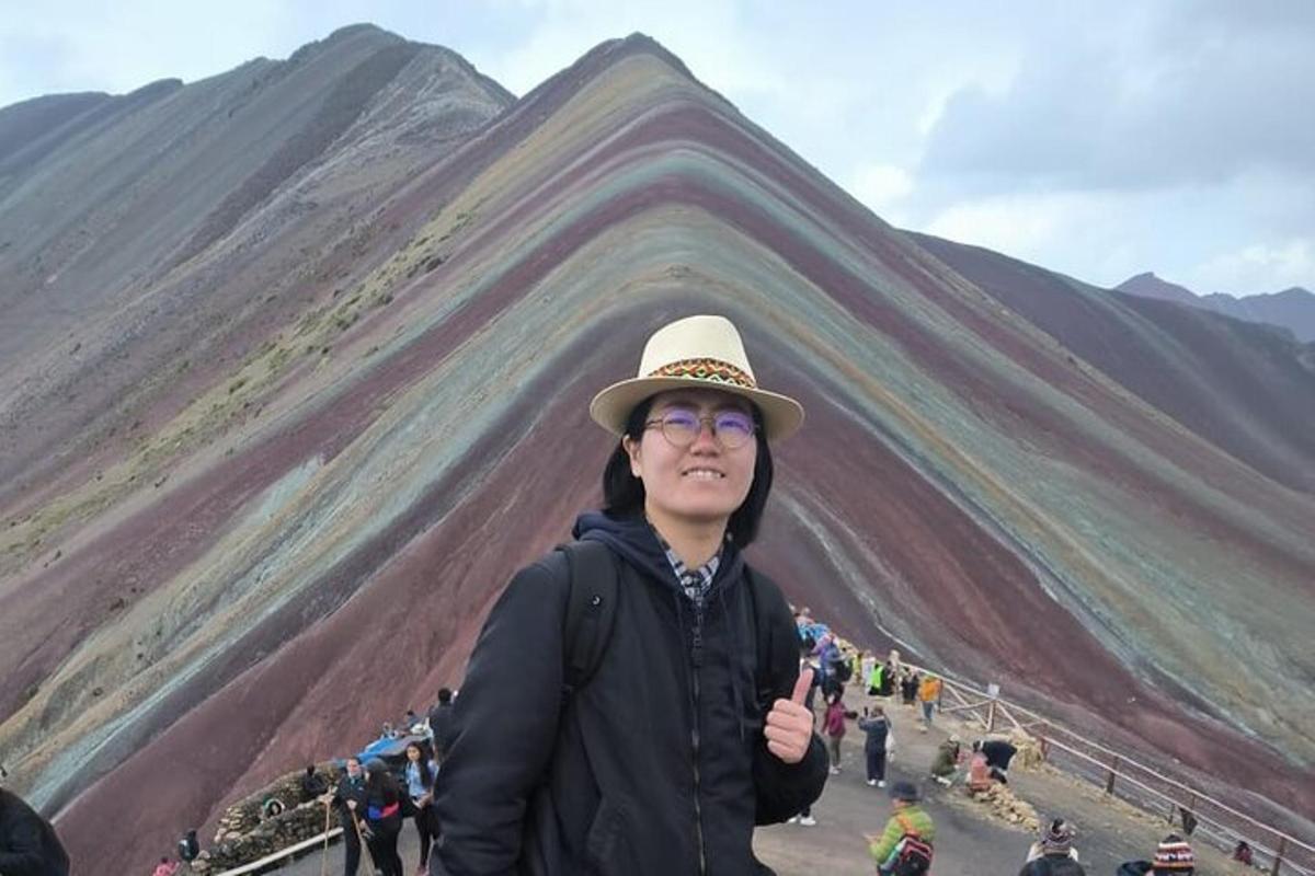 산 앞에 서 있는 모자를 쓴 여자