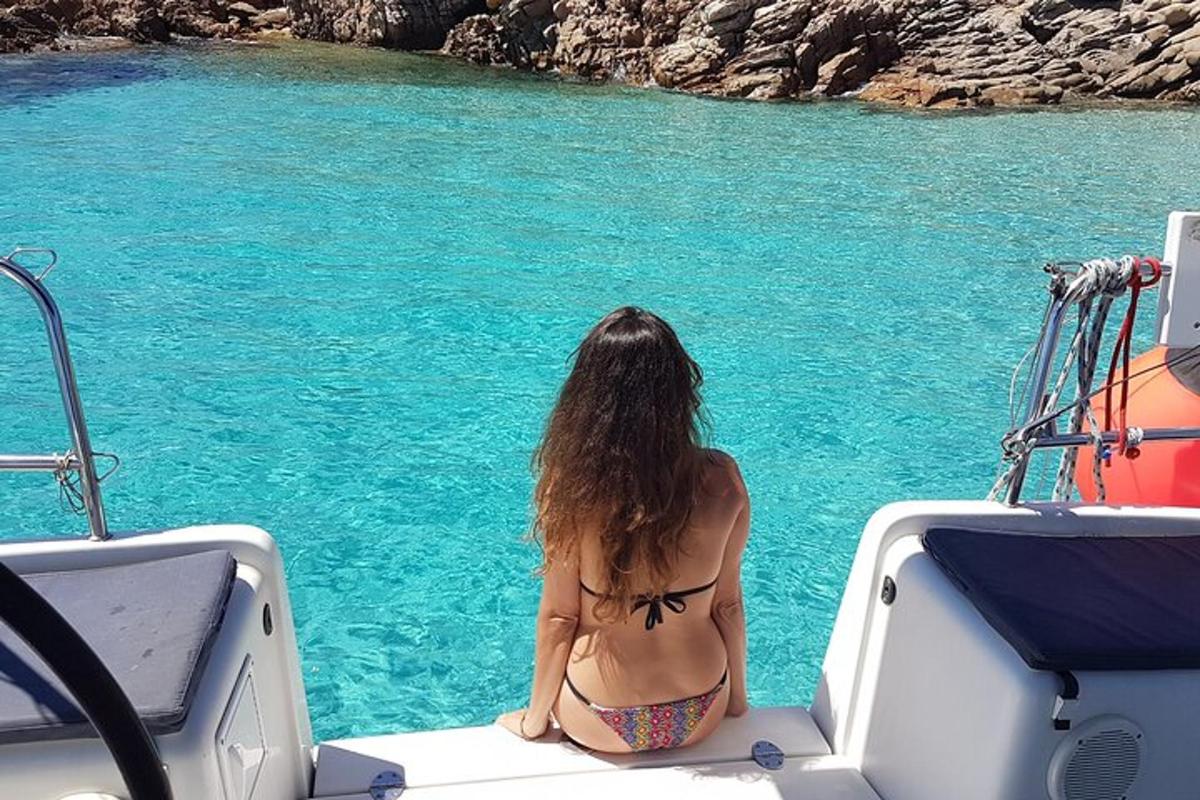 a woman in a bikini sitting on the back of a boat