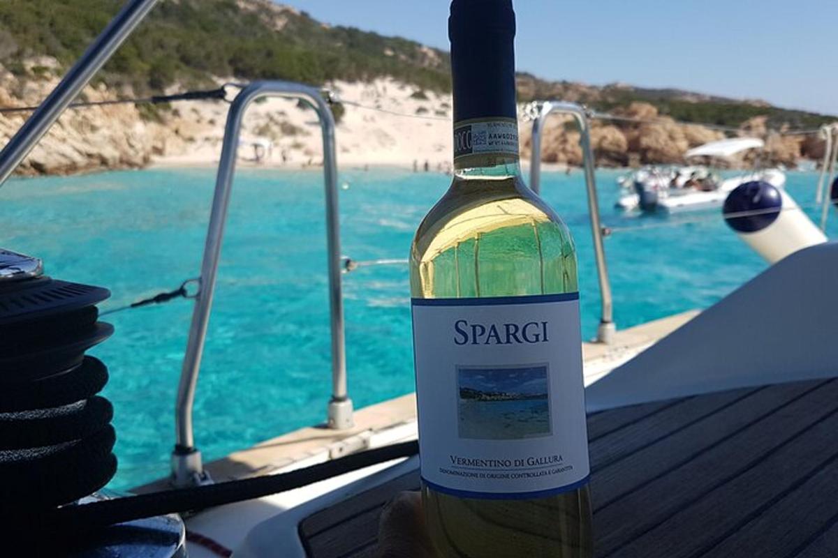 a bottle of wine sitting on a table next to the ocean