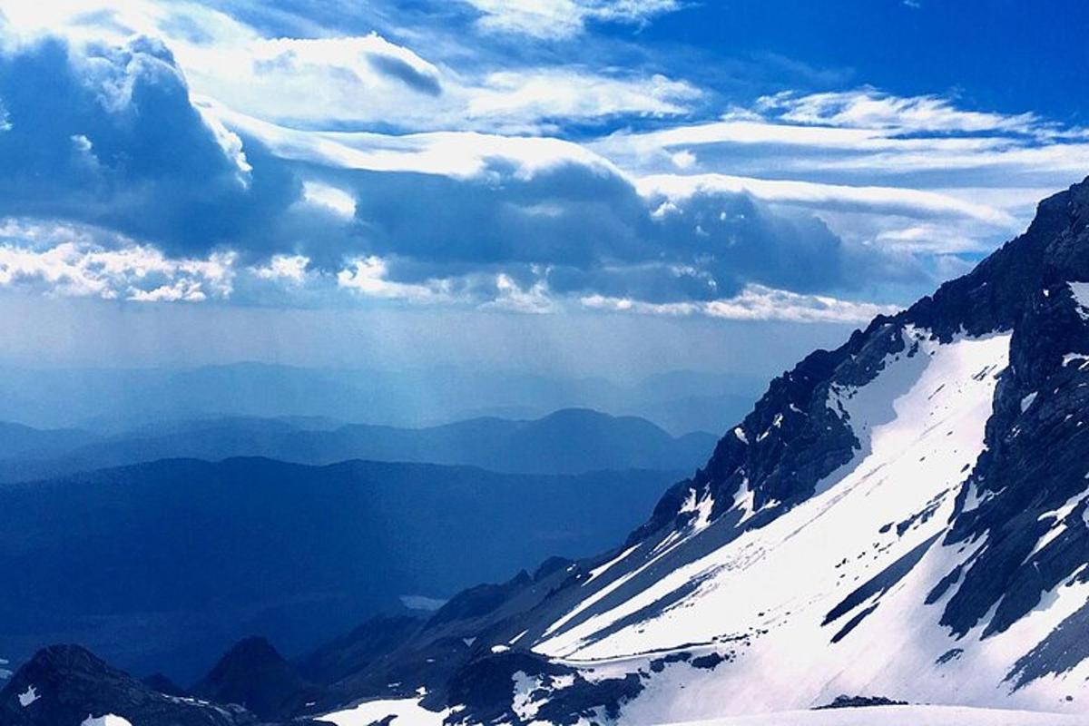 una vista di una montagna innevata con nuvole nel cielo
