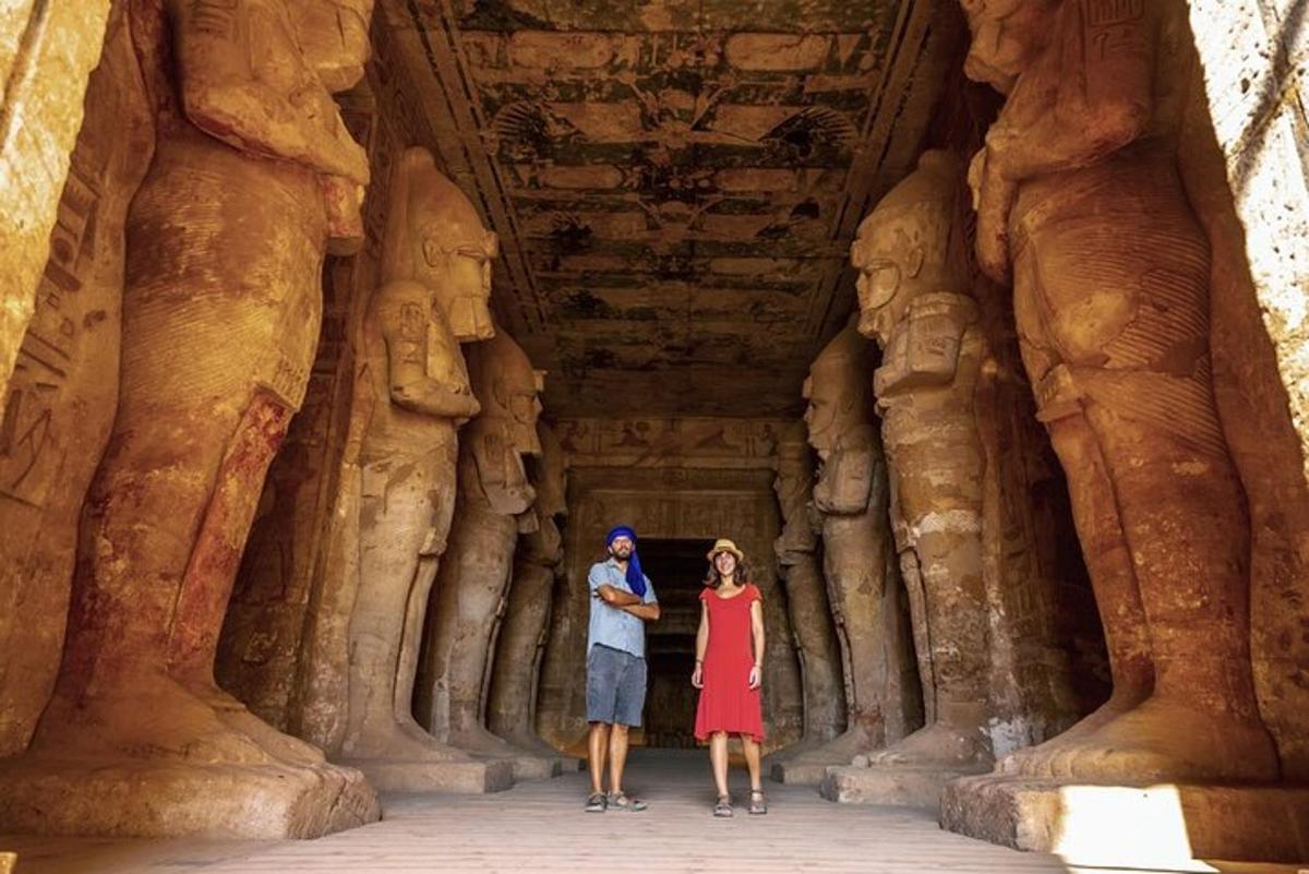 a man and woman standing in a cave with statues