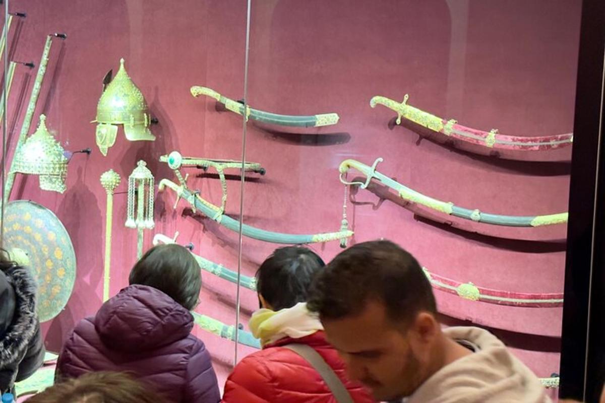 eine Gruppe von Menschen sitzt vor einer Wand mit Rohren