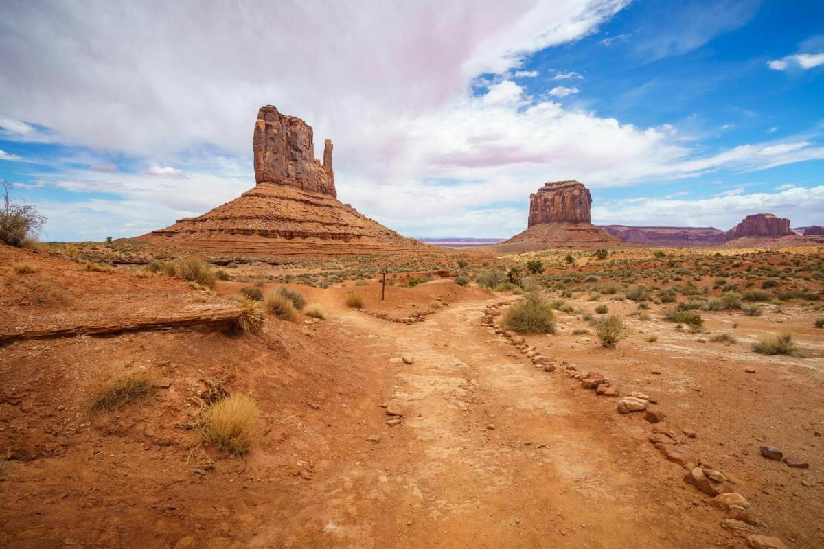 a dirt road in the desert with rock formations