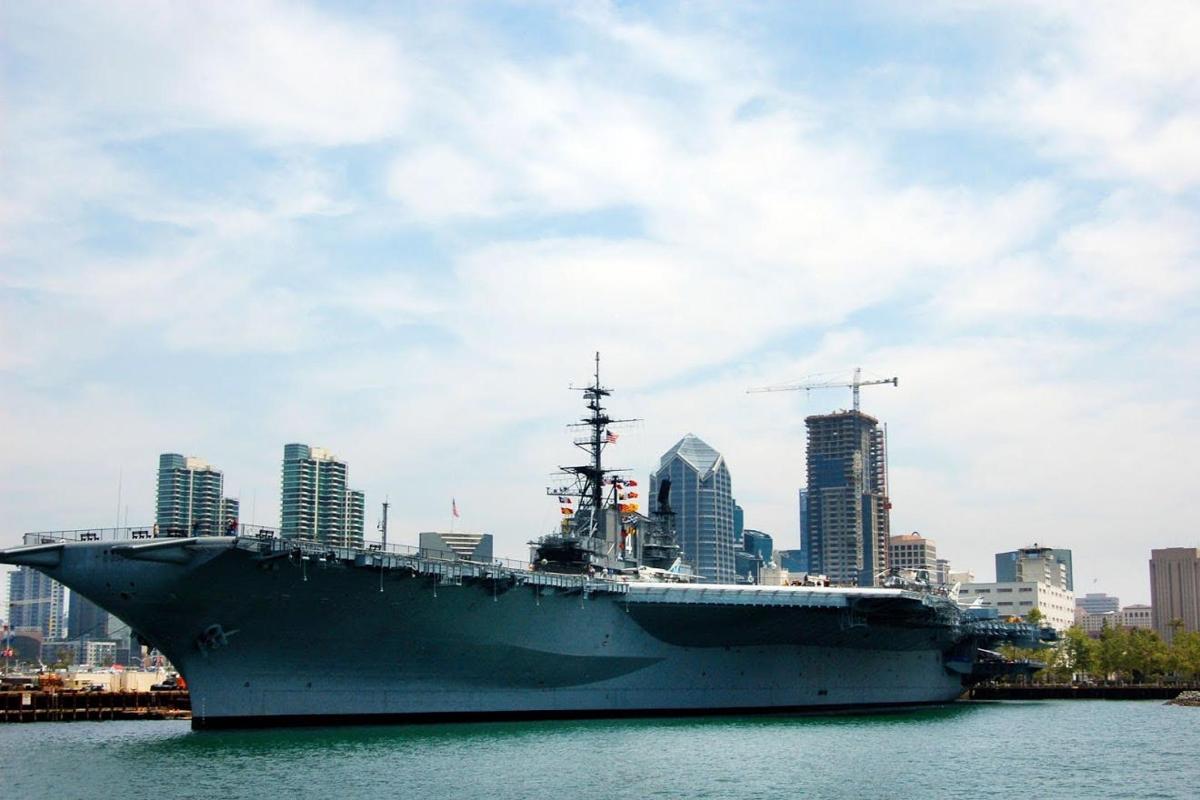 a large ship in the water with a city in the background