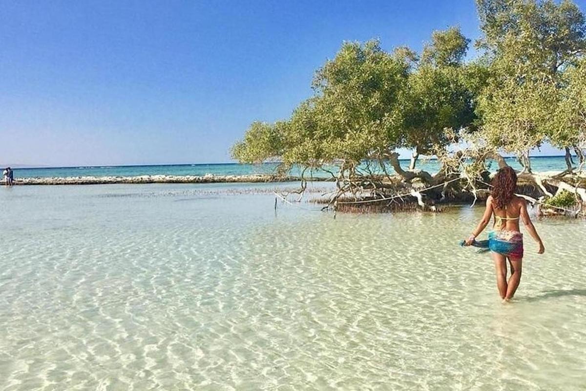 a woman walking in the water on a beach