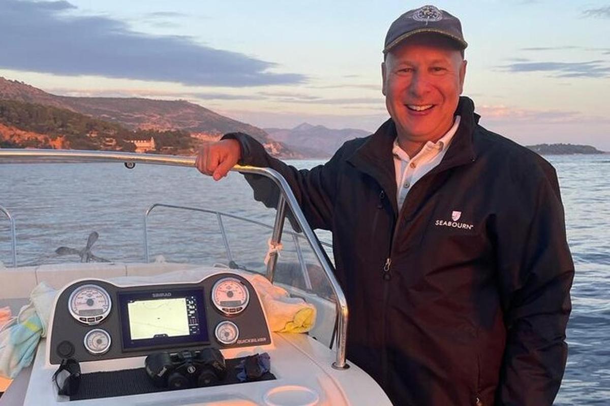 a man standing on a boat with a speedometer