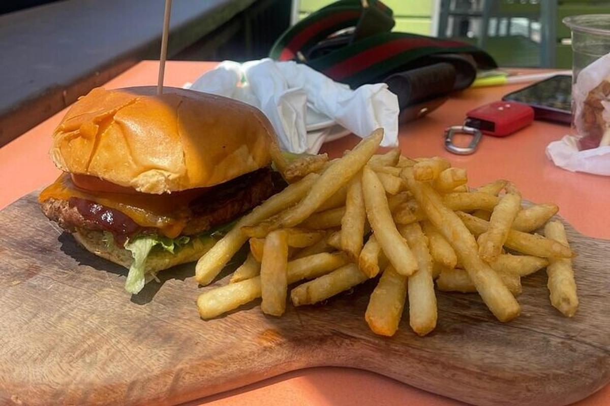 hamburger a hranolky na dřevěném prkénku