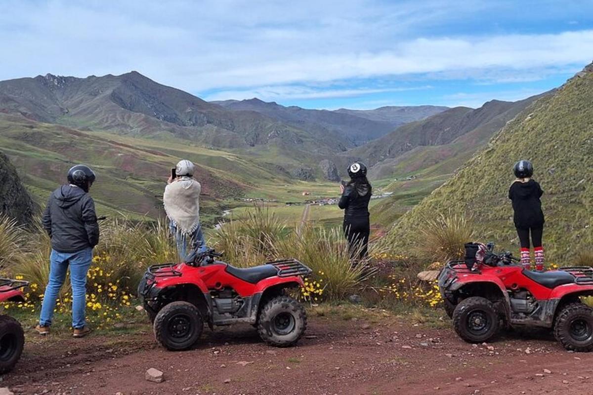 un gruppo di persone in piedi attorno ai quad su una montagna