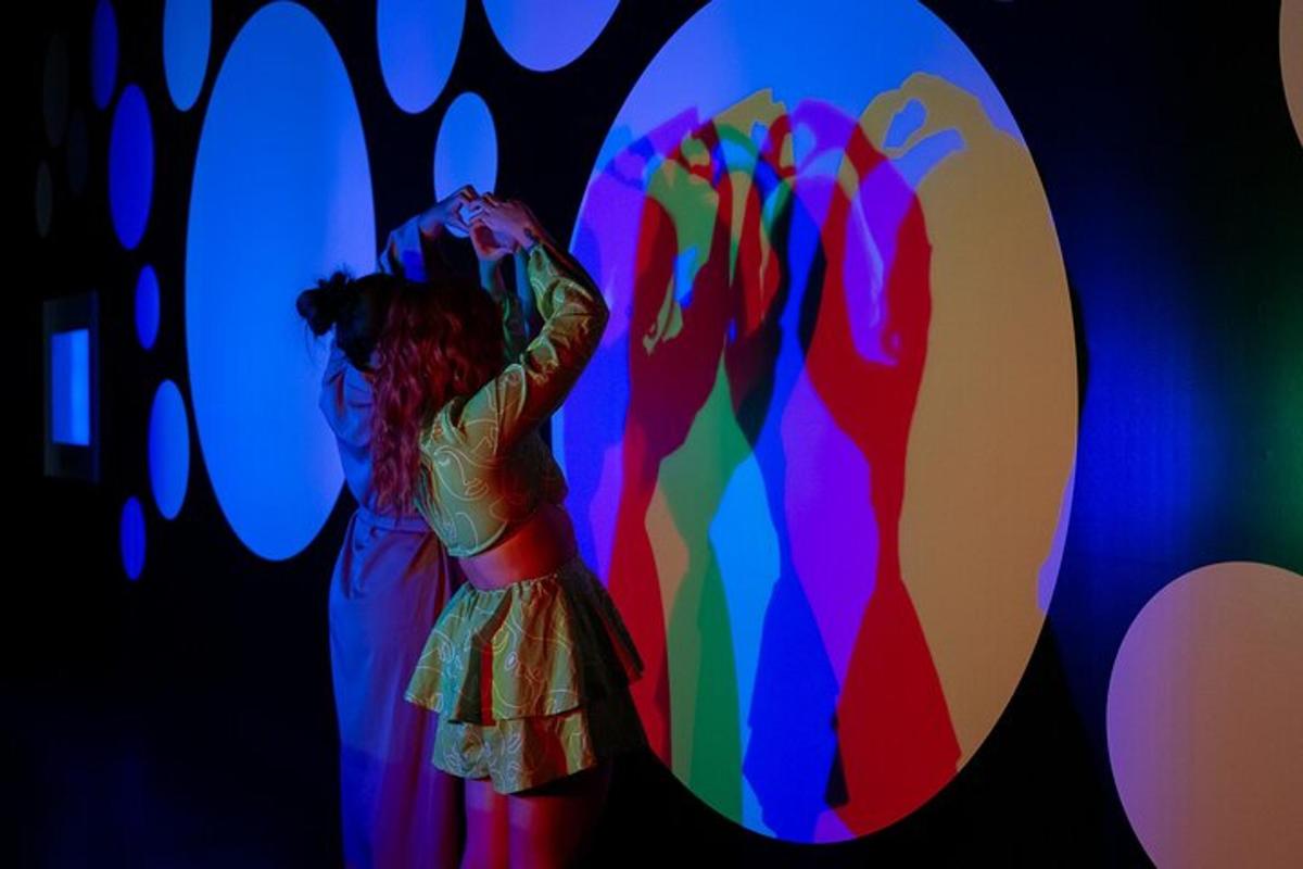 a woman is standing in front of a colorful mirror