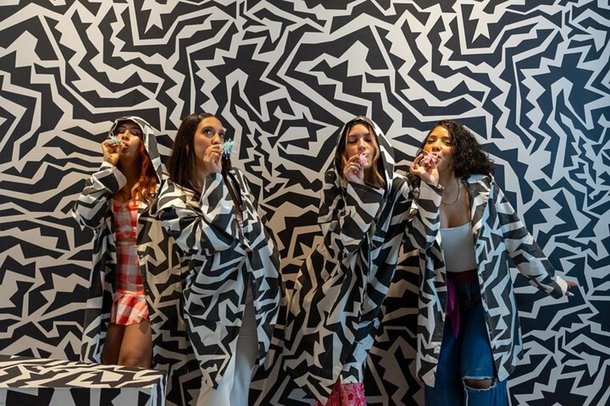 a group of three women singing in front of a wall