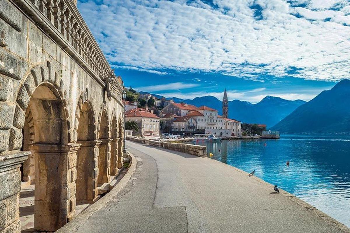 una strada accanto a uno specchio d'acqua con una città