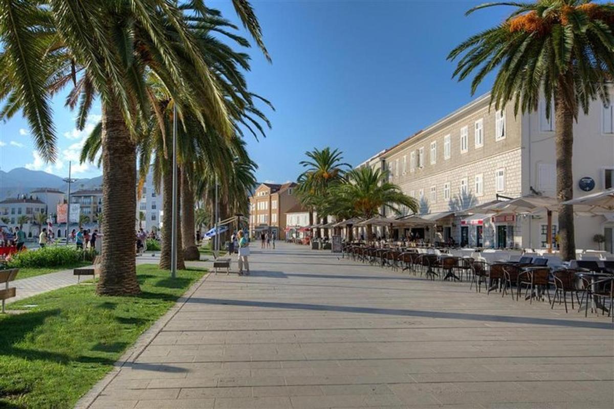 una strada con palme, tavoli e sedie