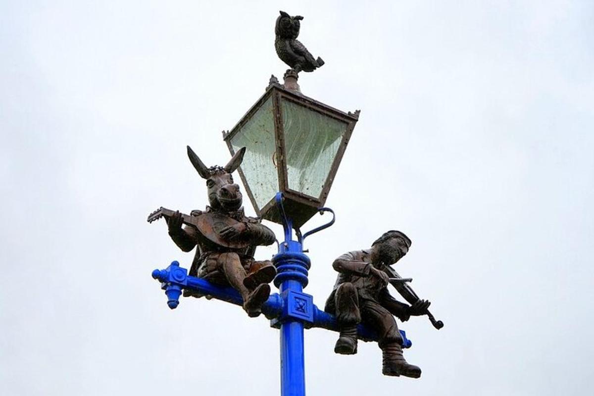 uma estátua de dois homens em cima de um poste de luz