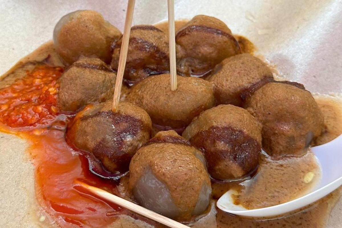 en tallerken mad med kødboller og sauce og spisepinde