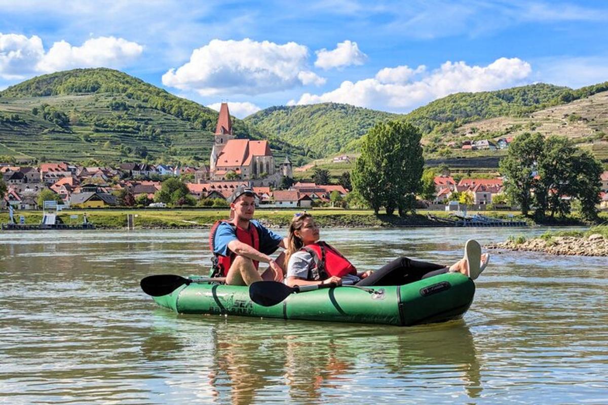Două persoane călătoresc pe o plută pe apă