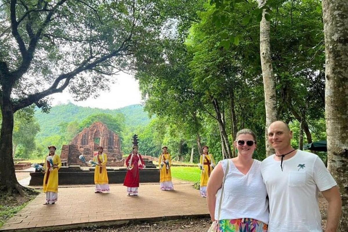 a man and a woman standing in front of a temple