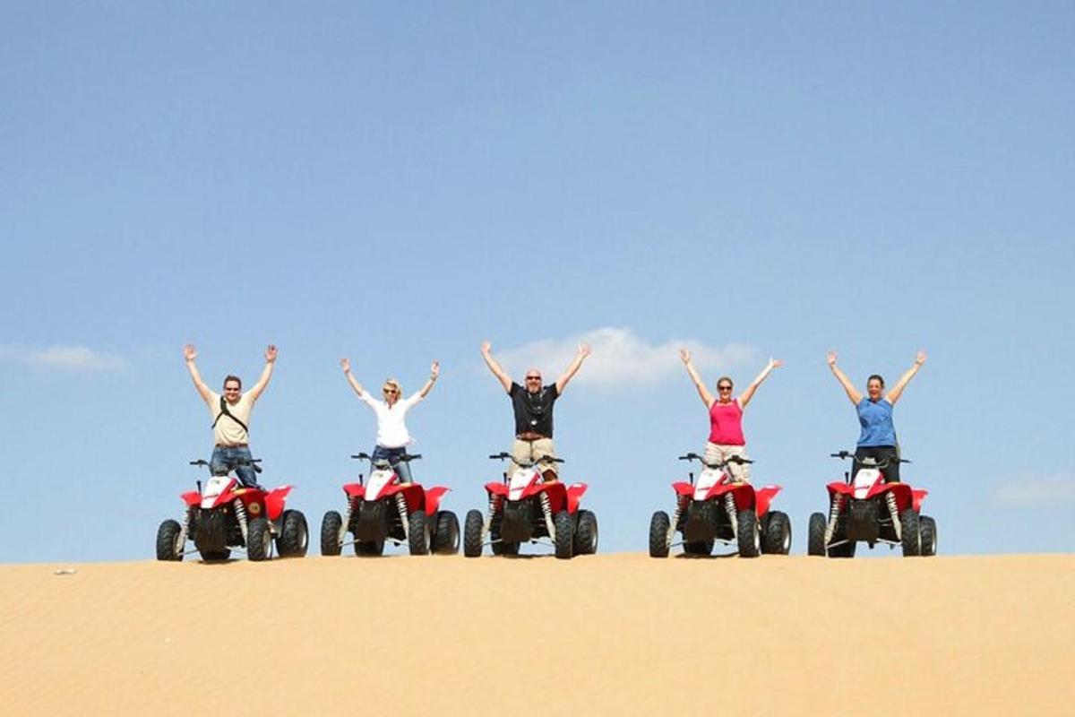 un grup de oameni pe ATV-uri în nisip