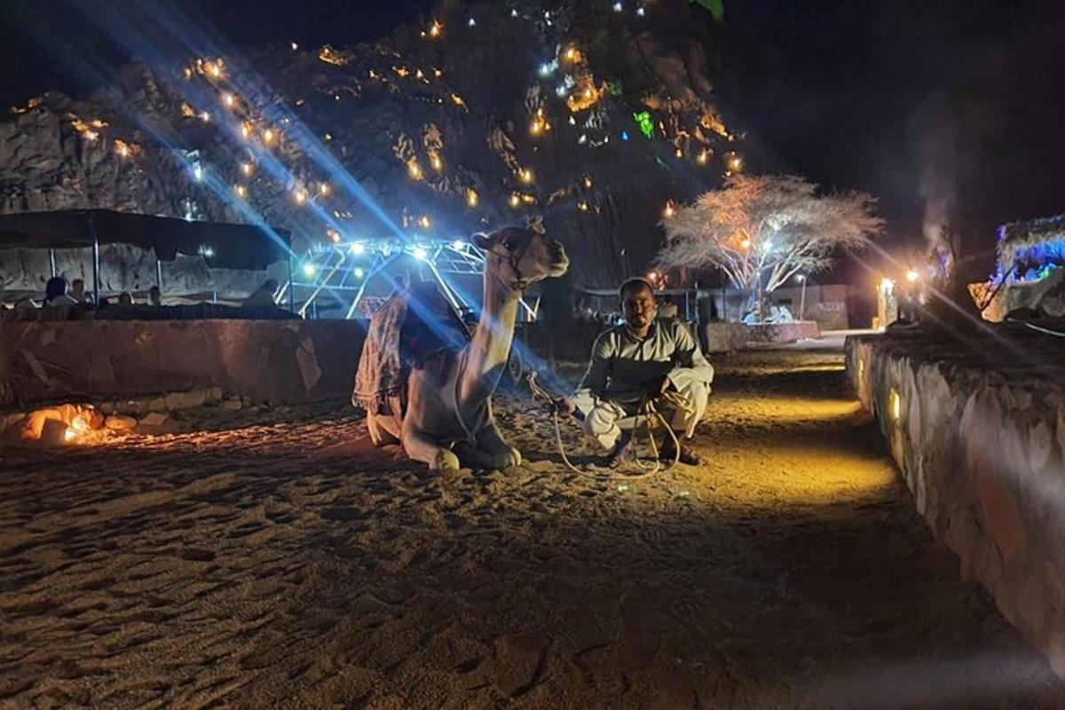 a man and a woman sitting on the beach at night