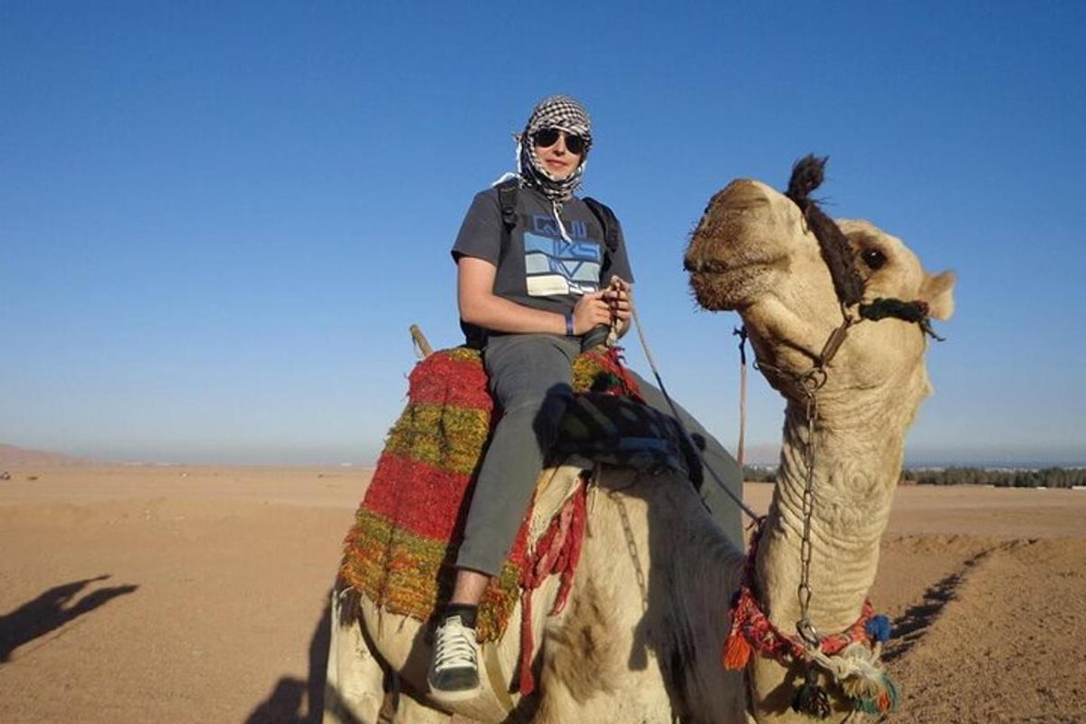una donna che cavalca un cammello nel deserto