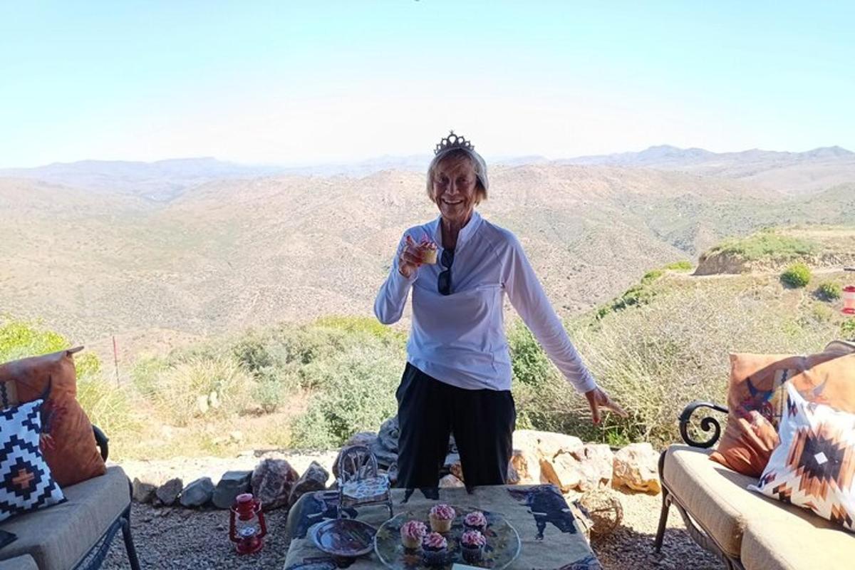 an older woman standing in front of a table