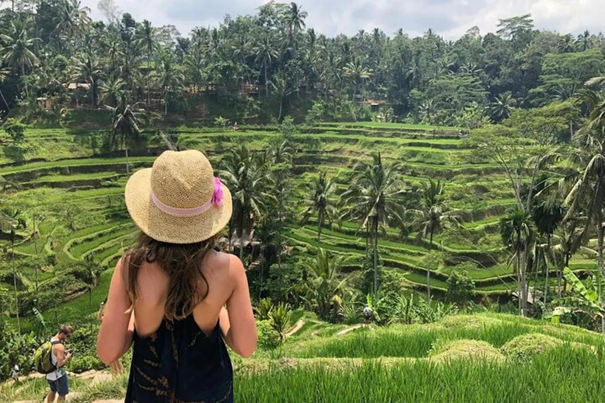 a woman in a hat looking at a rice field
