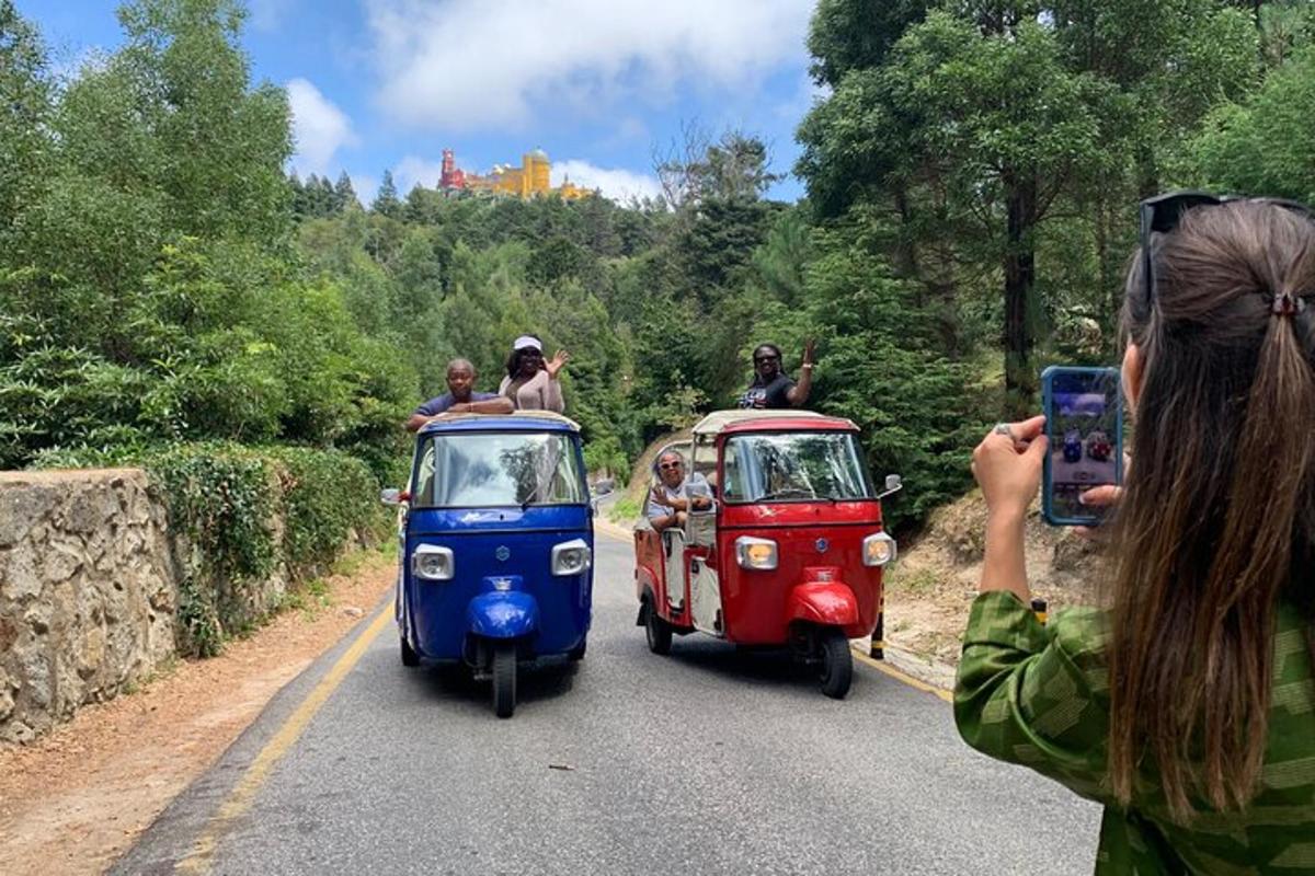 a woman taking a picture of three vespas driving down a road