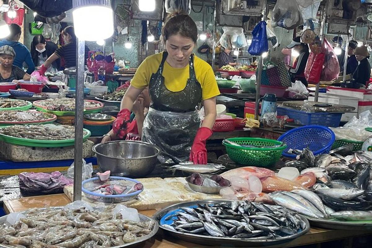 seorang wanita menyediakan makanan di pasar dengan makanan laut