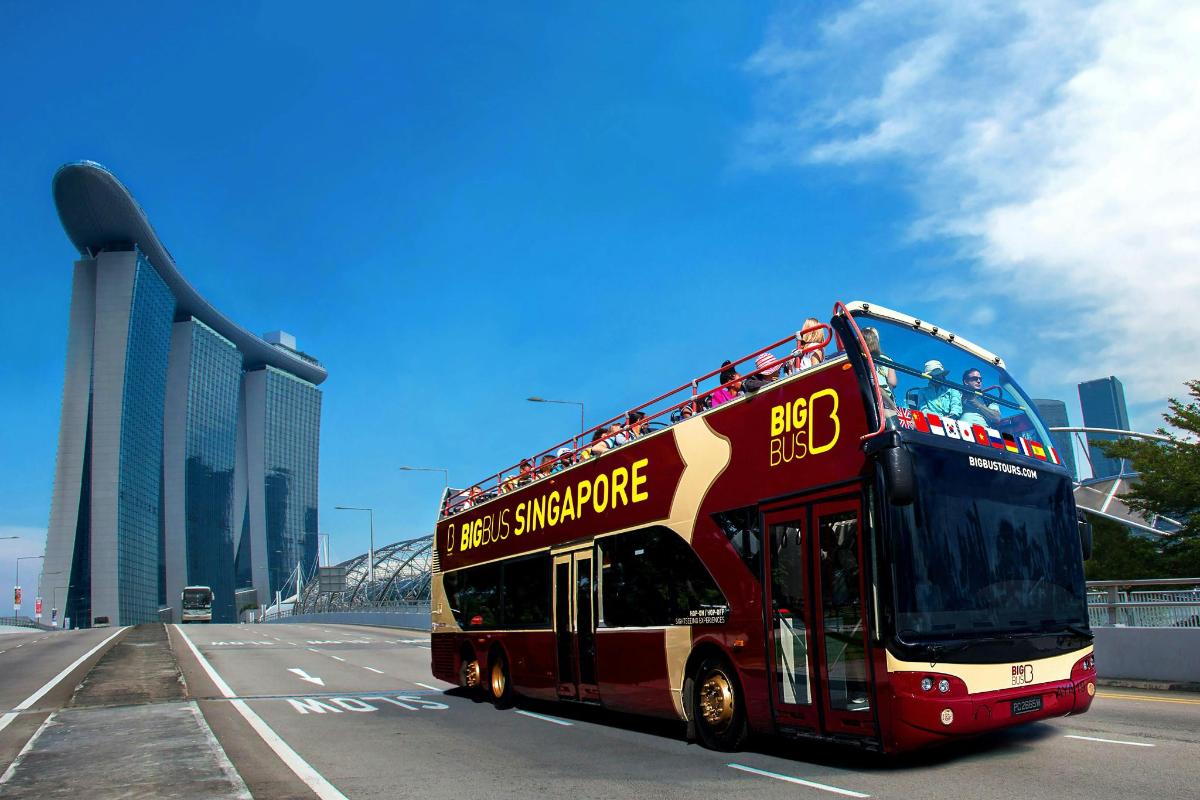 a red double decker bus driving down a street