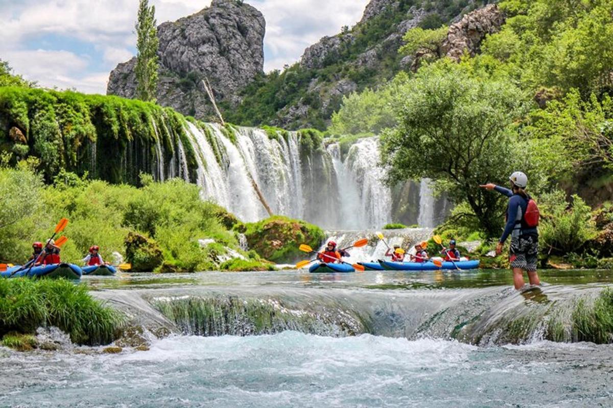 skupina lidí sjíždějících vodopád na raftu