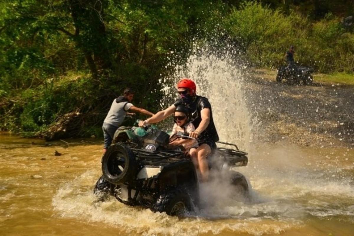 skupina lidí na čtyřkolce ve vodě