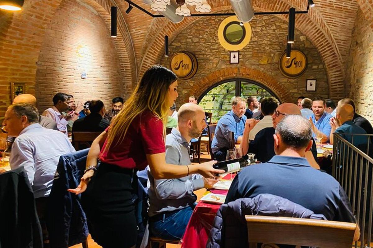 o femeie care stă în fața unei mulțimi de oameni la mese