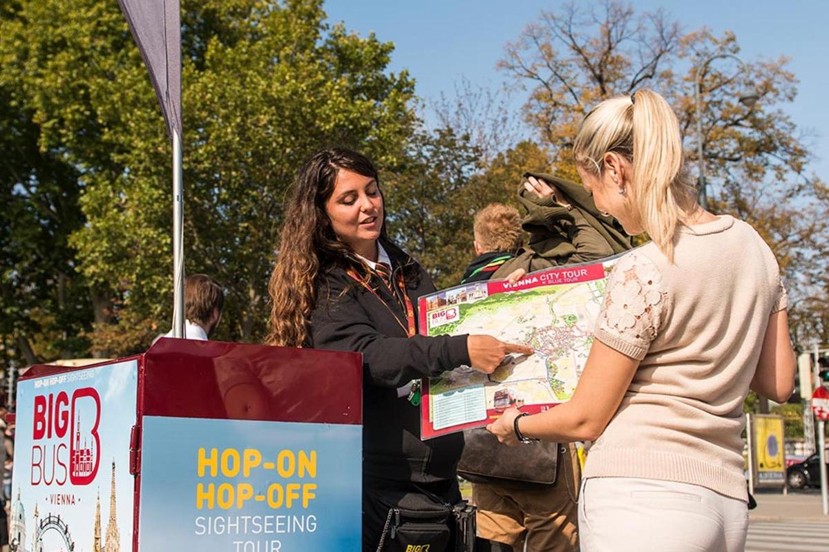 a woman standing next to a woman holding a map