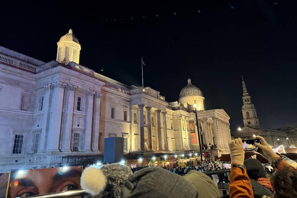 una folla di persone che scatta foto di un edificio di notte