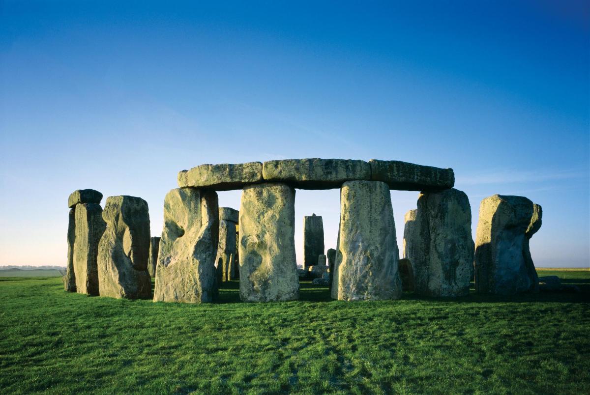 um antigo monumento de Stonehenge em um campo gramado