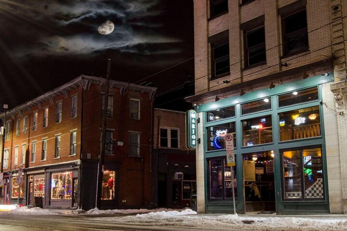 a city street at night with buildings and a clock