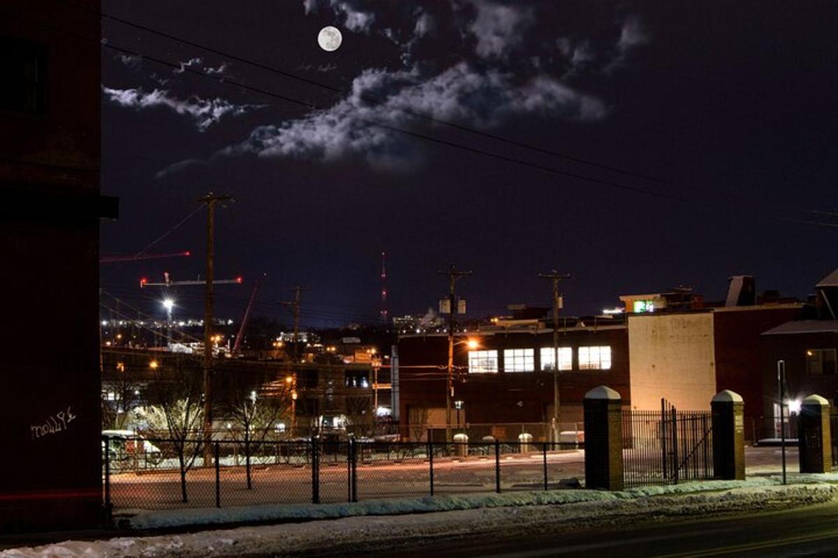 a view of a city at night with the moon
