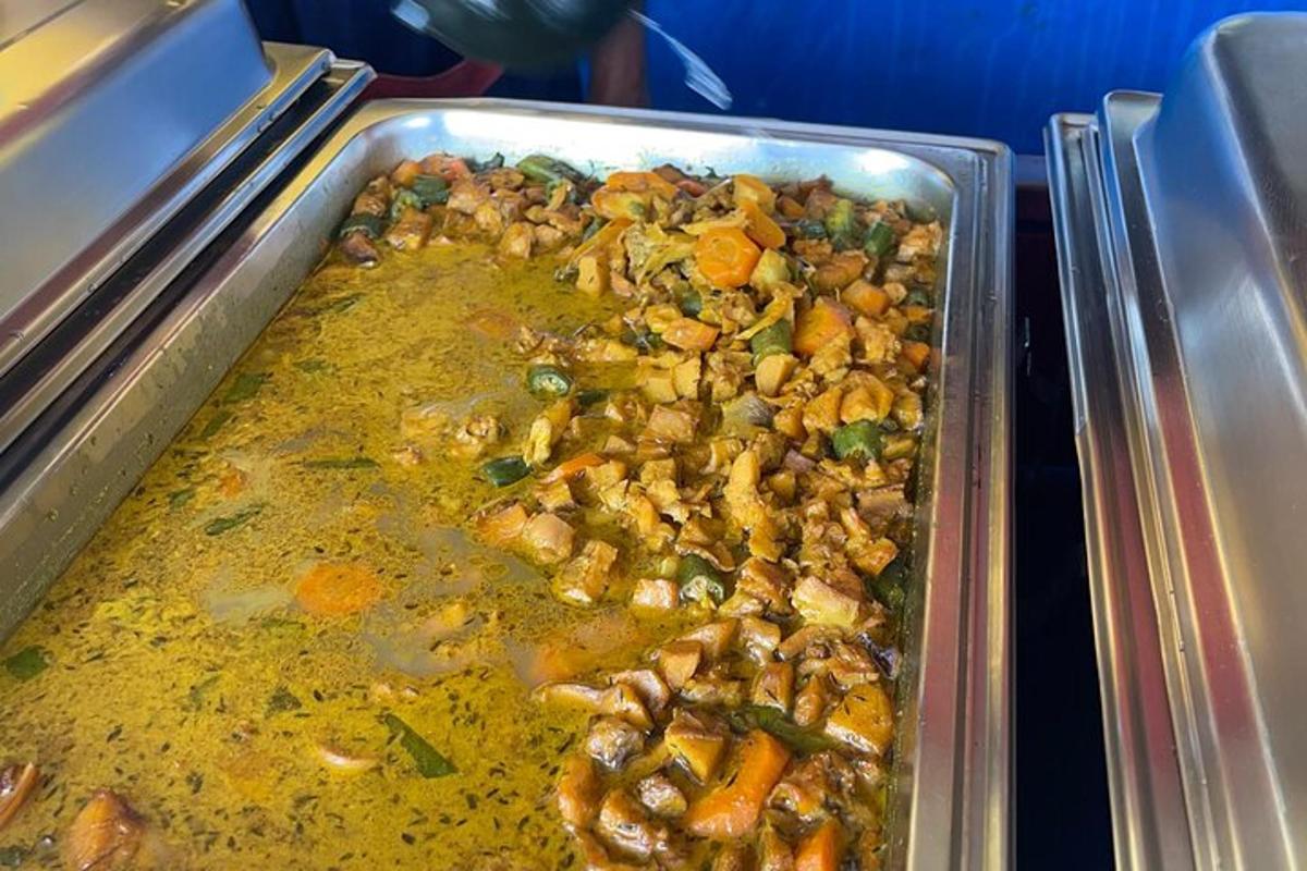 Una sartén con comida con pollo y verduras sobre una mesa.