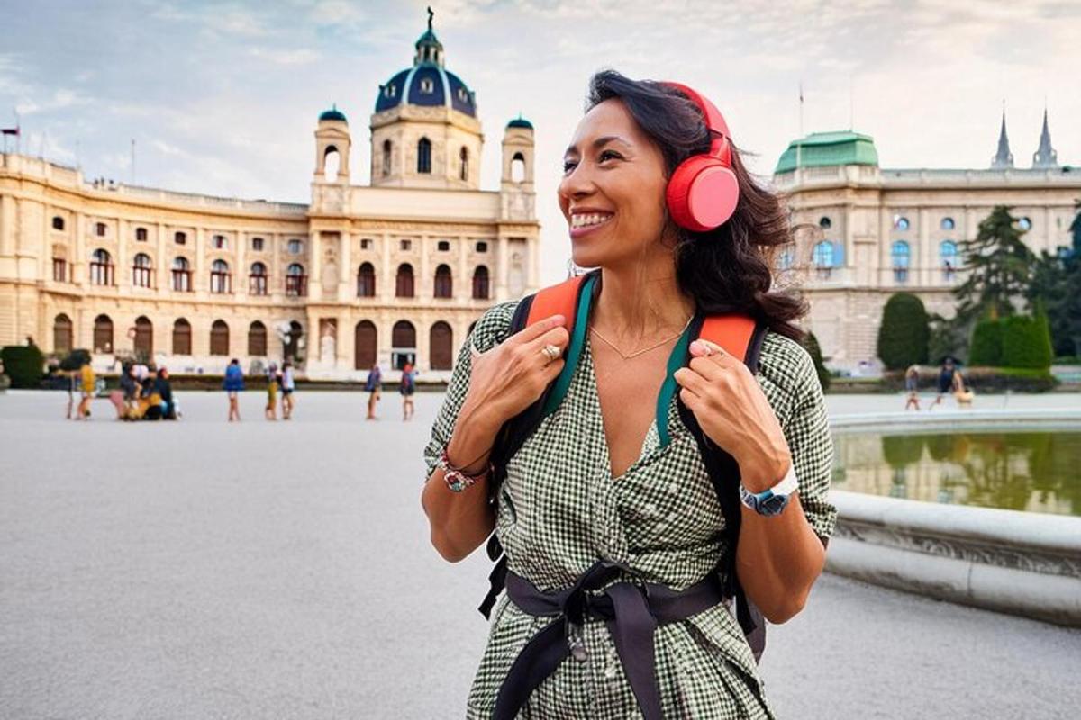 Una mujer con auriculares parada frente a un edificio.