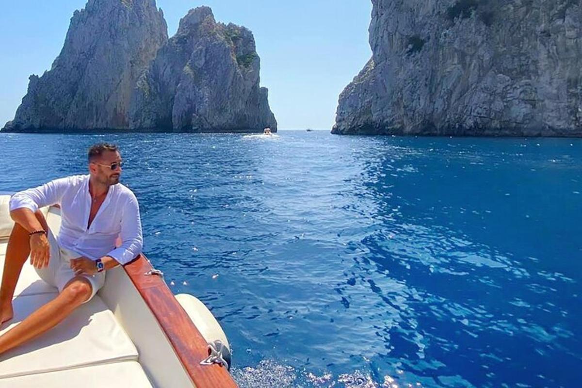 ένας άντρας που κάθεται στην άκρη μιας βάρκας στο νερό