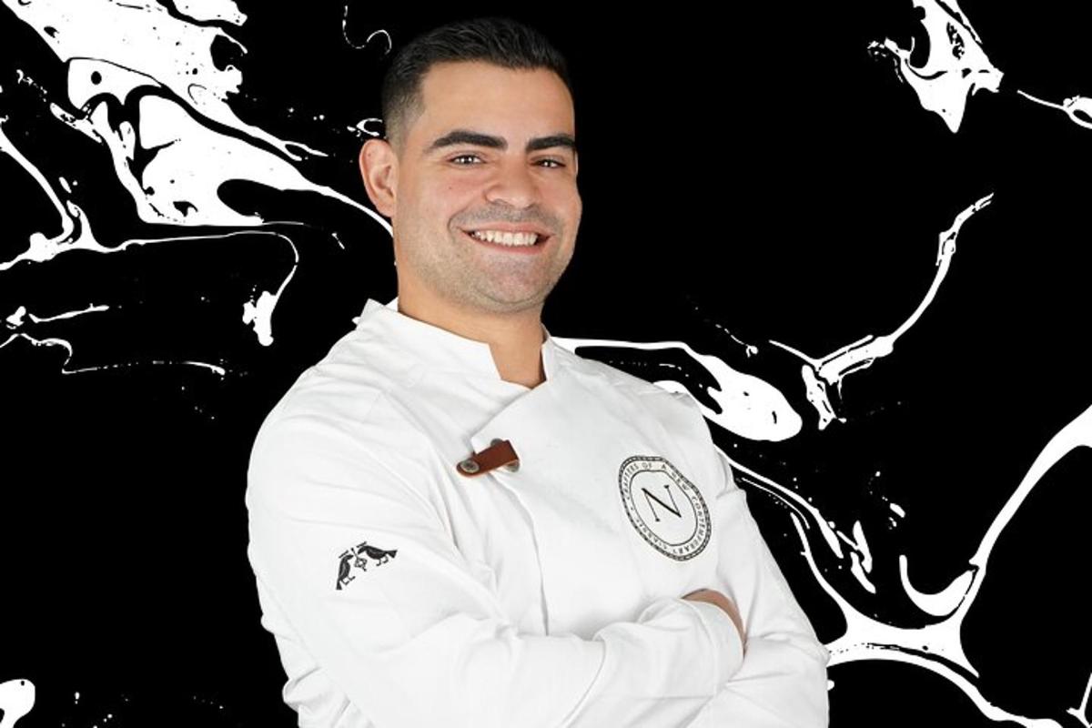 muž v kuchařské uniformě stojí se zkříženýma rukama