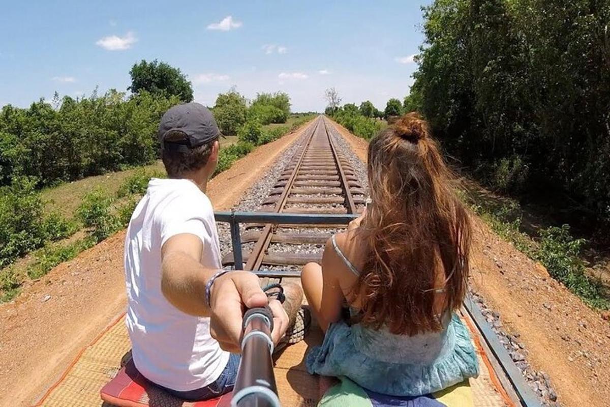 muž a žena jedoucí vlakem po železničních kolejích