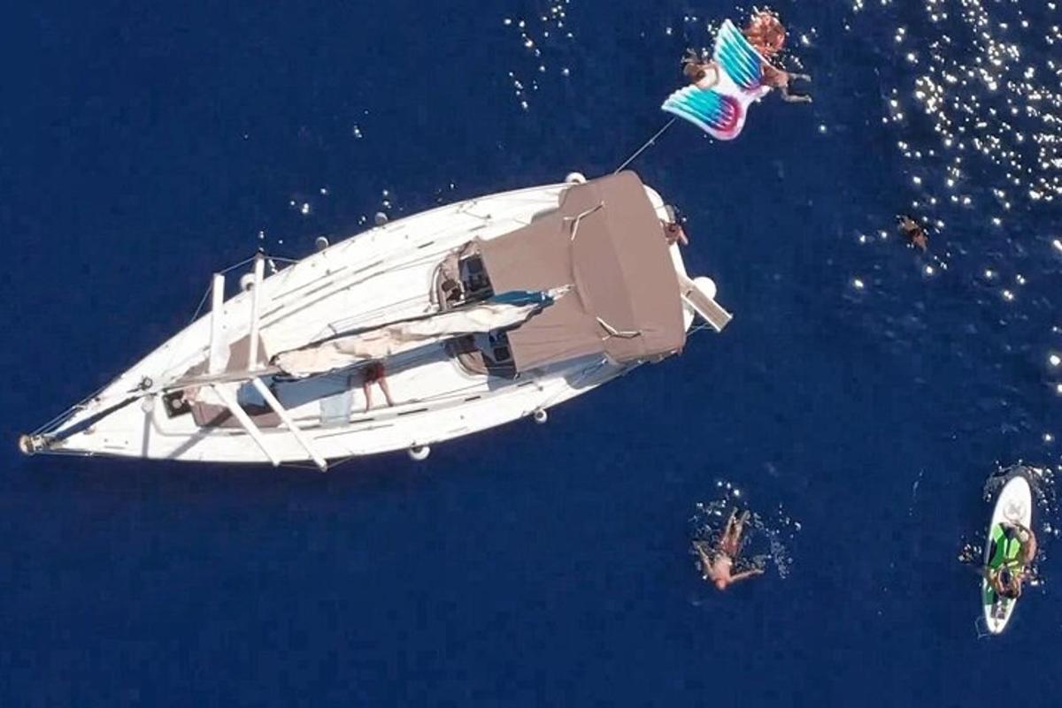 una barca che galleggia nell'acqua con delle persone a bordo