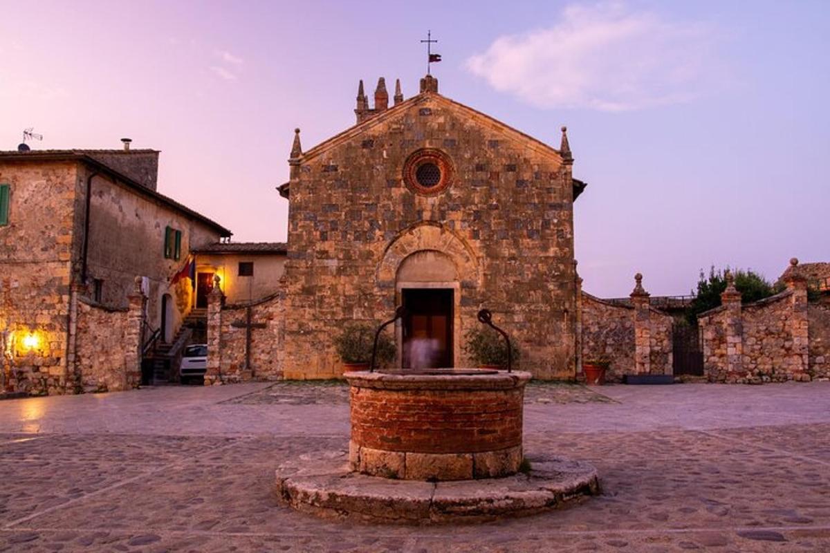 uma velha igreja de pedra com uma fonte na frente