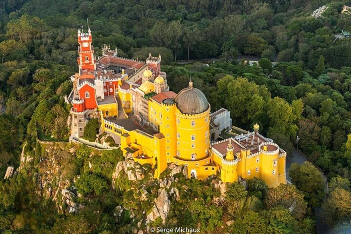 un castel galben mare pe vârful unui munte